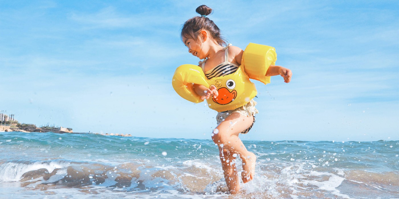 kid at beach with floaties resized